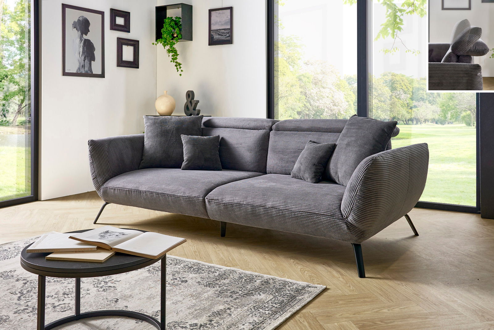 Graues Megasofa mit Kissen in modernem Wohnzimmer, seitliche Perspektive