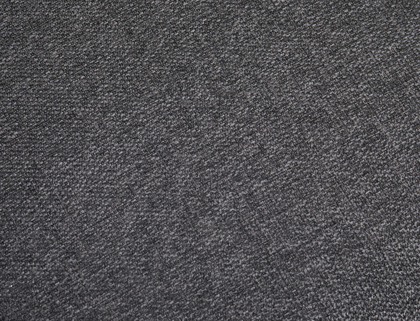 Nahaufnahme eines grauen Stoffes mit feiner Textur, perspektivisch von oben betrachtet.