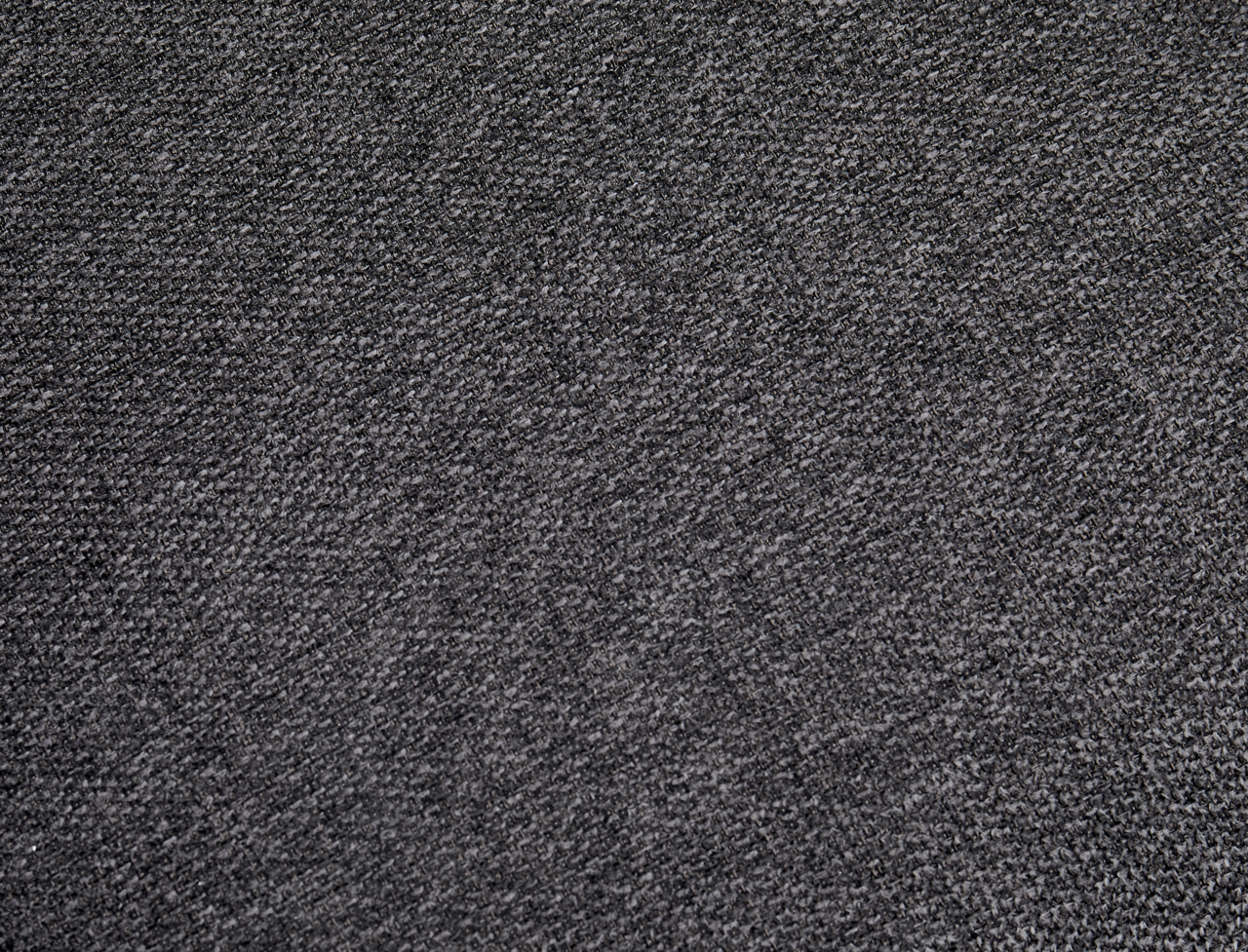 Nahaufnahme eines grauen Stoffes mit feiner Textur, perspektivisch von oben betrachtet.