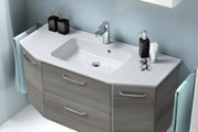 Modernes Badezimmer-Waschtisch-Set mit weißem Aufsatzwaschbecken, verchromter Armatur und grauem Unterschrank mit Schubladen, fotografiert in schräger Frontansicht von oben