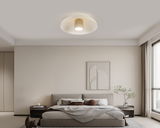 Moderne LED-Deckenleuchte in einem stilvollen Schlafzimmer, von unten betrachtet.