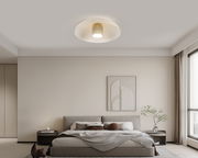 Moderne LED-Deckenleuchte in einem stilvollen Schlafzimmer, von unten betrachtet.