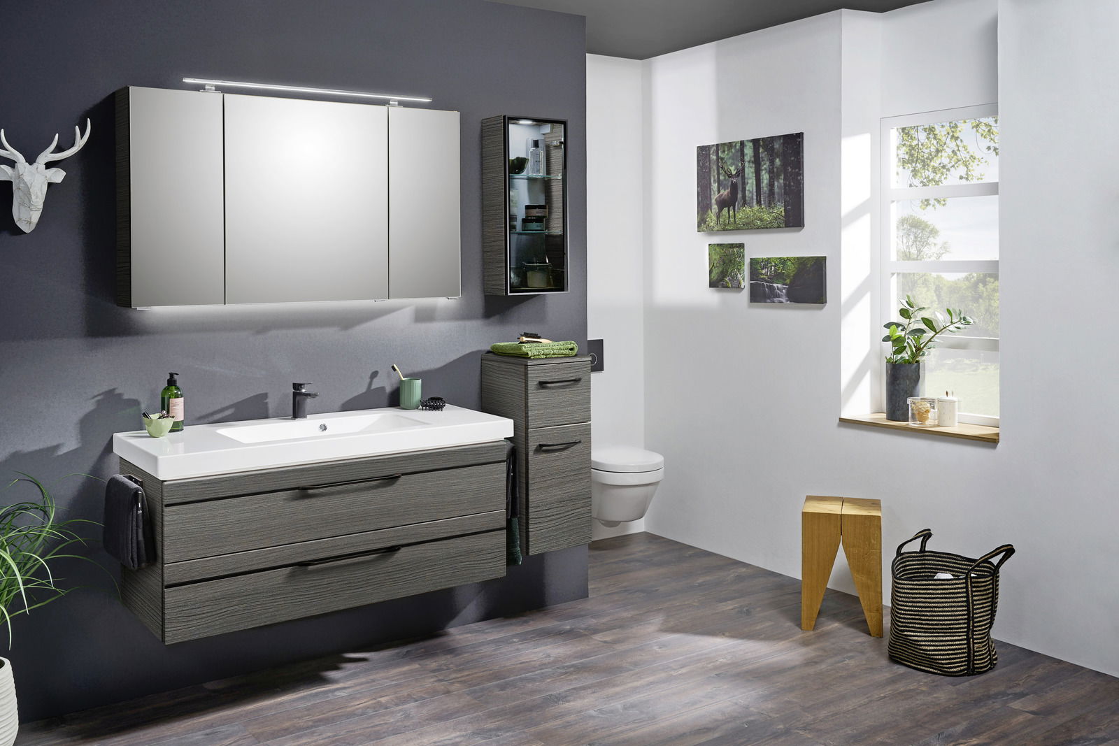 Moderne Badkombination mit Spiegel, Waschbecken und Schränken in einer stilvollen Badezimmerumgebung, seitliche Perspektive.