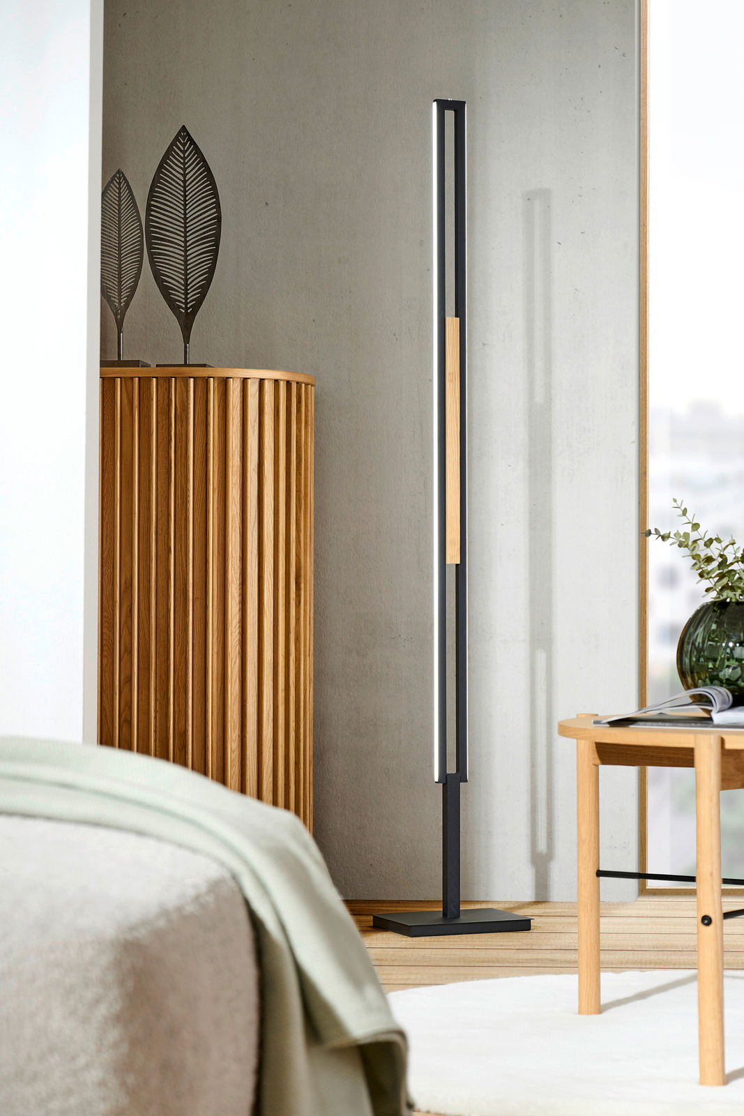 Moderne LED-Stehleuchte in einem stilvollen Wohnzimmer, seitliche Perspektive