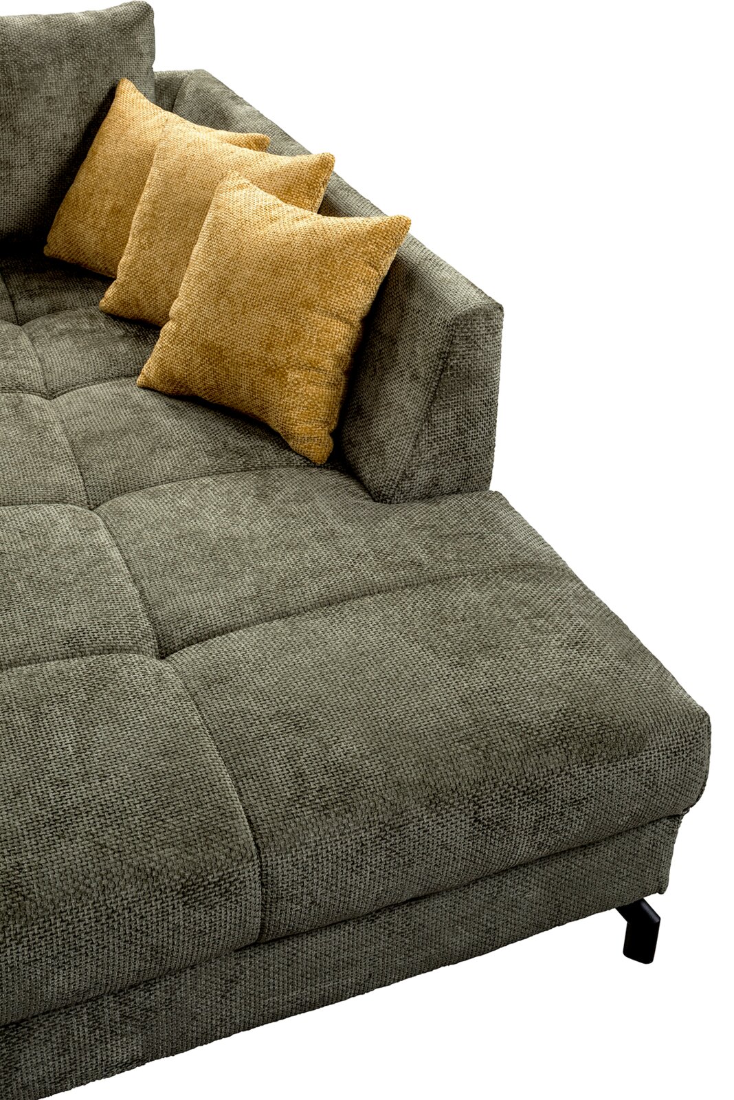Detailansicht einer grauen, gepolsterten Chaiselongue/Sofa-Liege mit gesteppter Sitzfläche, Armlehne und zwei gelben Zierkissen, fotografiert aus schräger Vogelperspektive von oben.
