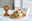 Kinder-Set 3-tlg. Connect Zoo mit Tiermotiven, bestehend aus Teller, Schüssel und Becher, auf einem Tisch mit einem Stofflöwen im Hintergrund, seitliche Perspektive