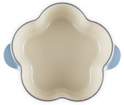 Blumenförmige Keramik-Auflaufform in Creme mit hellblauen Griffen, Draufsicht von oben auf weißem Hintergrund