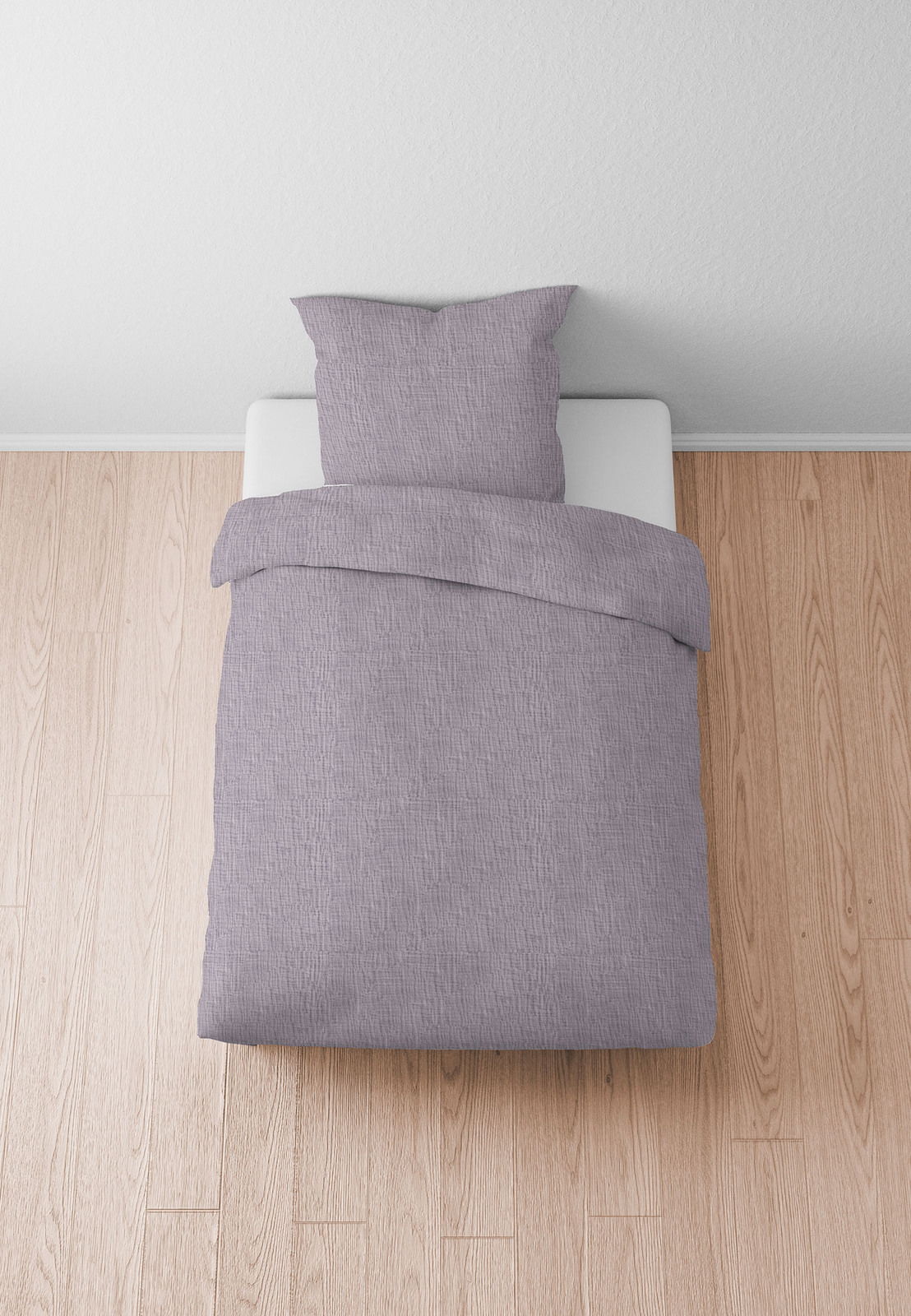 Graue Bettwäsche 155x220cm auf einem Bett, von oben fotografiert, auf hellem Holzboden.