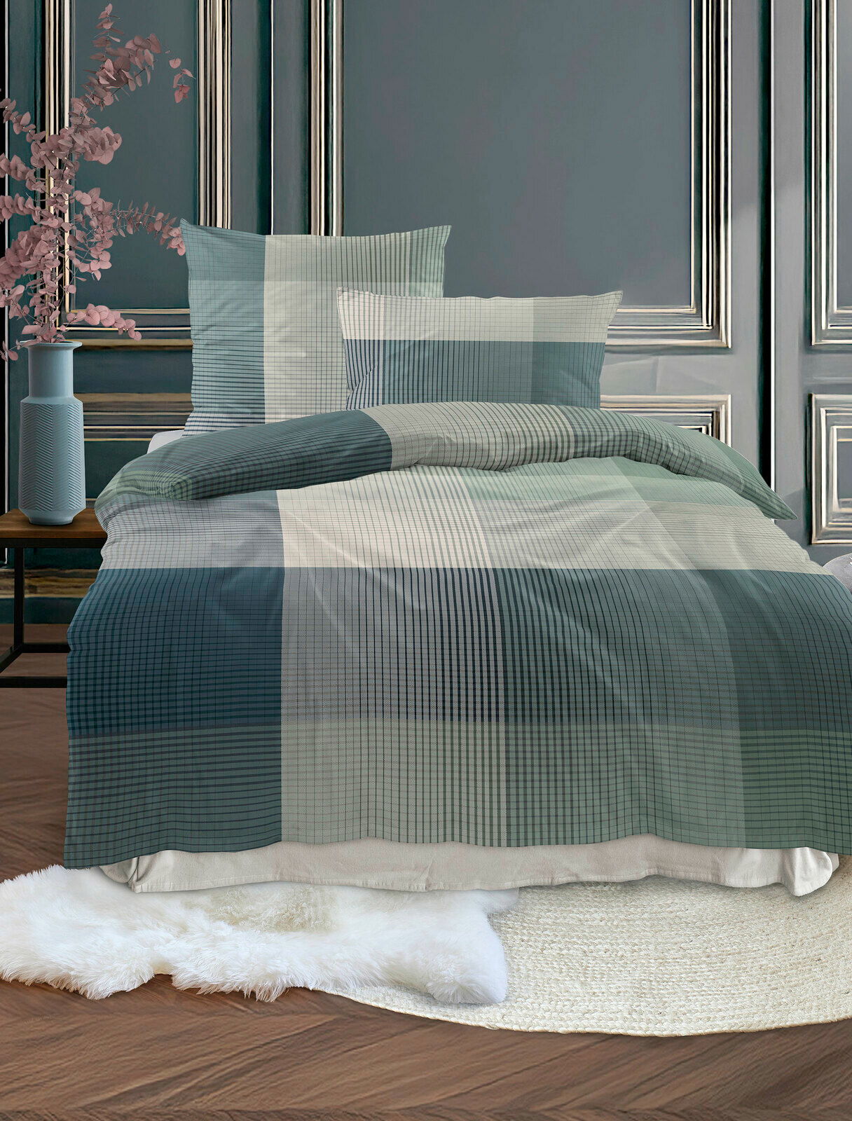 Bettwäsche-Set in einem eleganten, karierten Design in Blau- und Grautönen, auf einem Bett in einem stilvoll eingerichteten Raum, aus der Vorderansicht fotografiert.