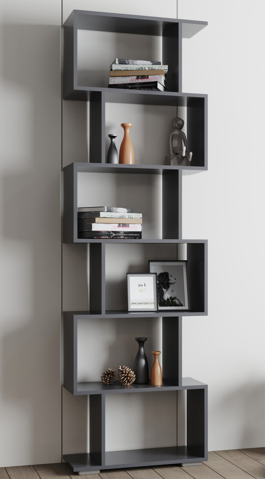 Modernes, asymmetrisches Standregal in Anthrazit mit offenen Fächern, dekoriert mit Büchern, Vasen, Bilderrahmen und Zapfen; frontal in leichter Seitenperspektive fotografiert.