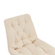 Nahaufnahme eines beigen, gepolsterten Stuhls mit gestepptem Design, Ansicht von schräg oben.