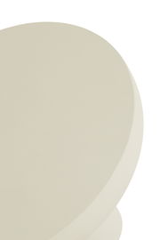 Nahaufnahme eines runden, cremefarbenen Couchtischs von oben betrachtet.