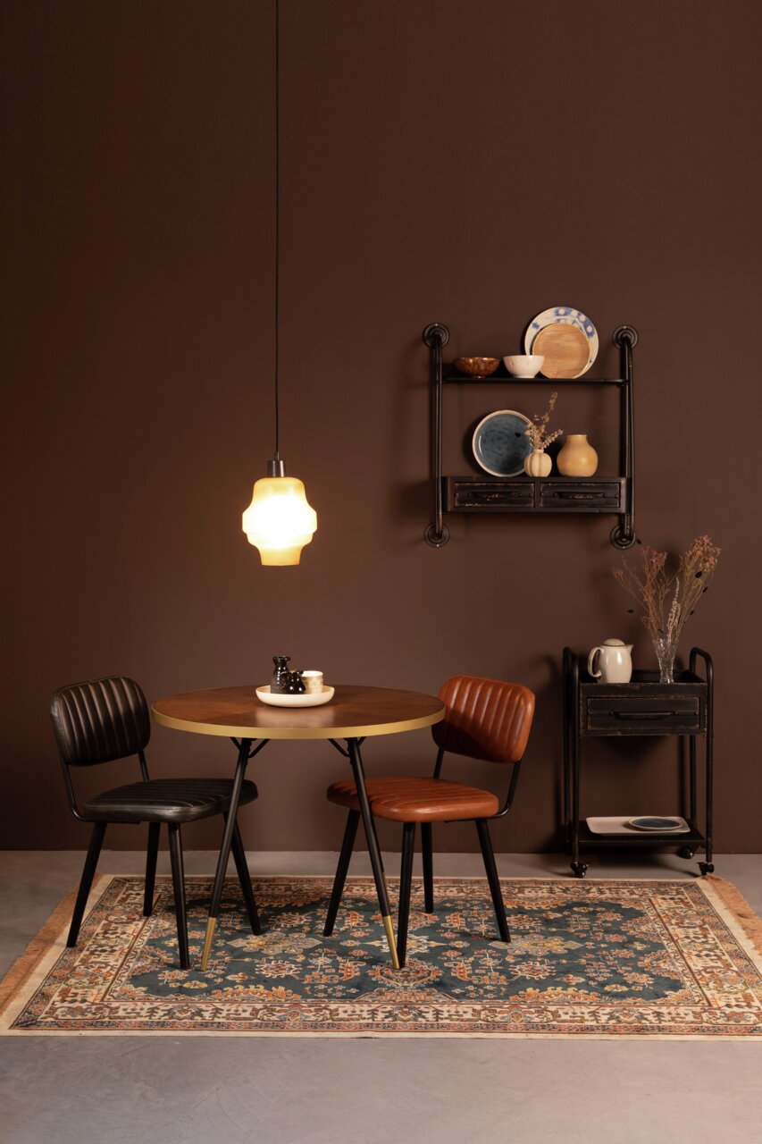Z2 Tapijt RAZ Een stijlvol ingerichte ruimte met een ronde houten tafel, twee stoelen en een decoratief tapijt in een warme, gezellige sfeer. Het tapijt is op de voorgrond te zien.
