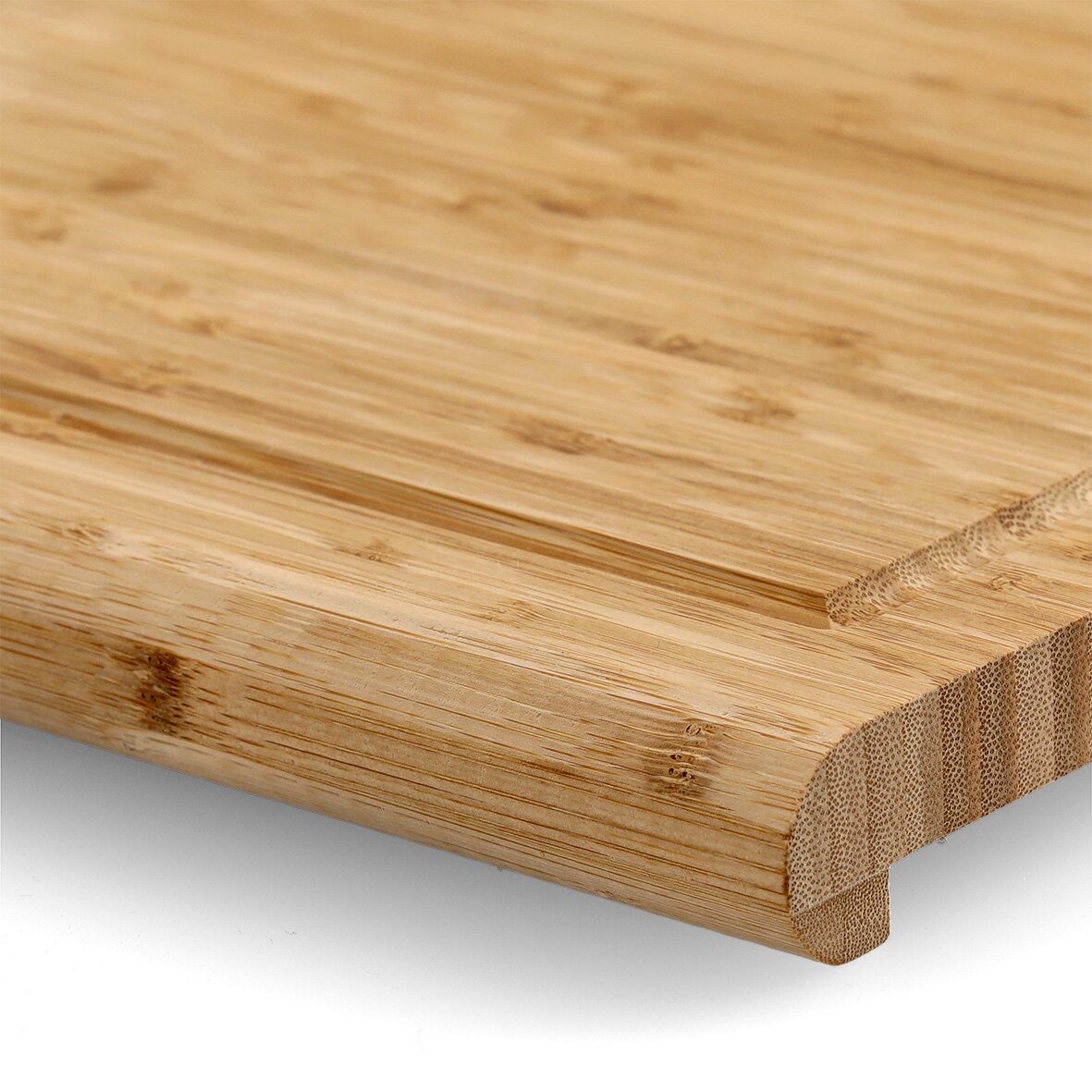 Nahaufnahme eines Back- und Tranchierbretts aus Holz mit abgerundeten Kanten, perspektivisch von der Seite aufgenommen.