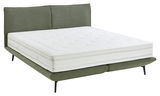 Boxspringbett mit grünem Stoffbezug und weißer Matratze, seitliche Perspektive