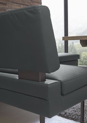 Detailansicht einer modernen Eckbank mit dunkelgrauem Lederbezug und Metallgestell, seitliche Perspektive.