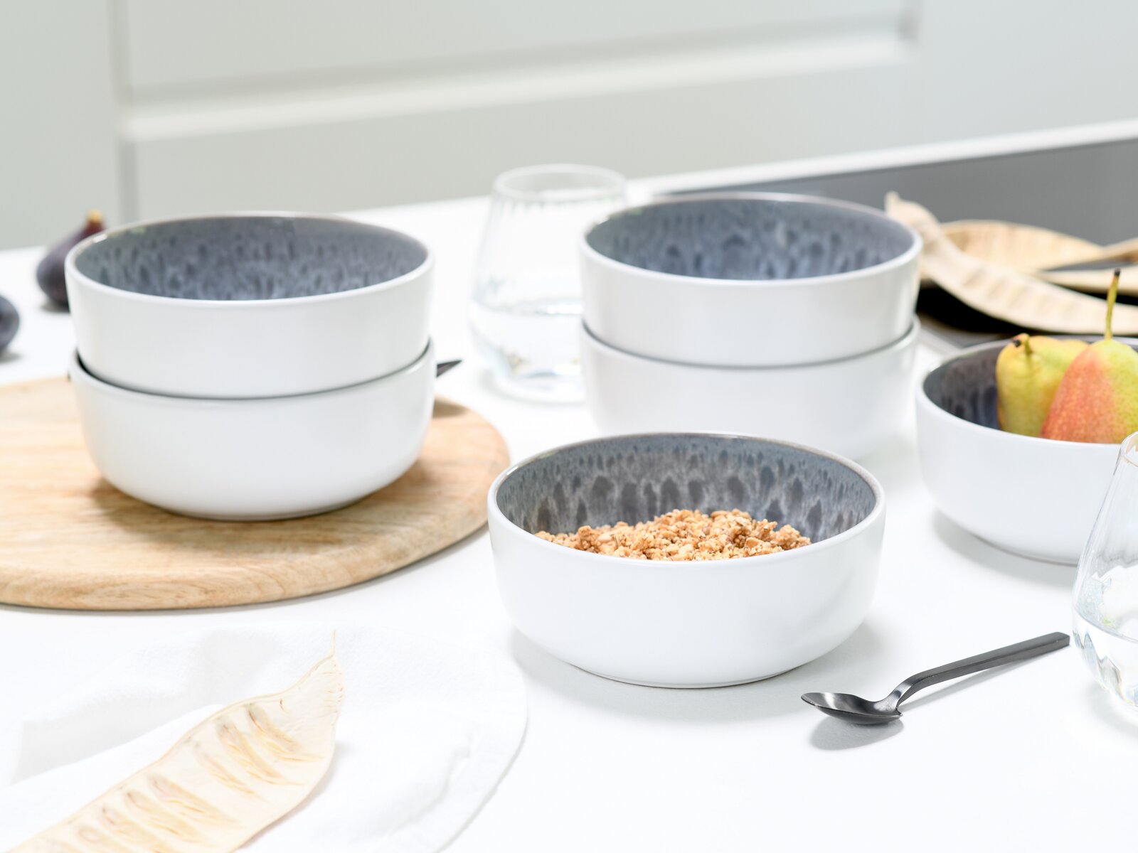 Kombiservice 16-tlg. Stone in moderner Küche, seitliche Perspektive auf Schalen mit grauer Innenseite und weißer Außenseite, gefüllt mit Müsli und Obst.