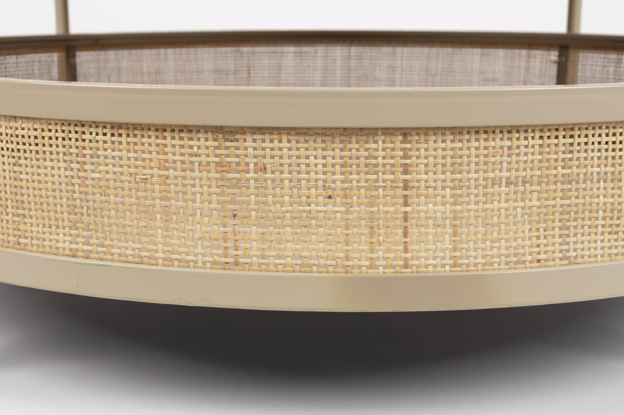 Nahaufnahme eines Couchtischs mit geflochtenem Rattan-Design und beiger Umrandung, seitliche Perspektive.