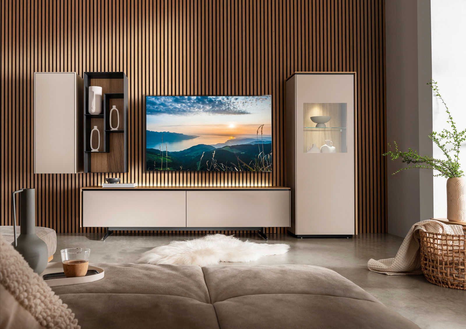 Moderne Wohnzimmermöbel mit TV-Element, Vitrine und Hängeschrank in einer stilvollen, minimalistischen Einrichtung. Perspektive von vorne.