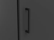 Nahaufnahme eines schwarzen Griffs an einer dunklen Schranktür, seitliche Perspektive.