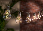 Lichterkette mit Glühbirnen-Design, beleuchtet in einer gemütlichen Abendatmosphäre, seitliche Perspektive