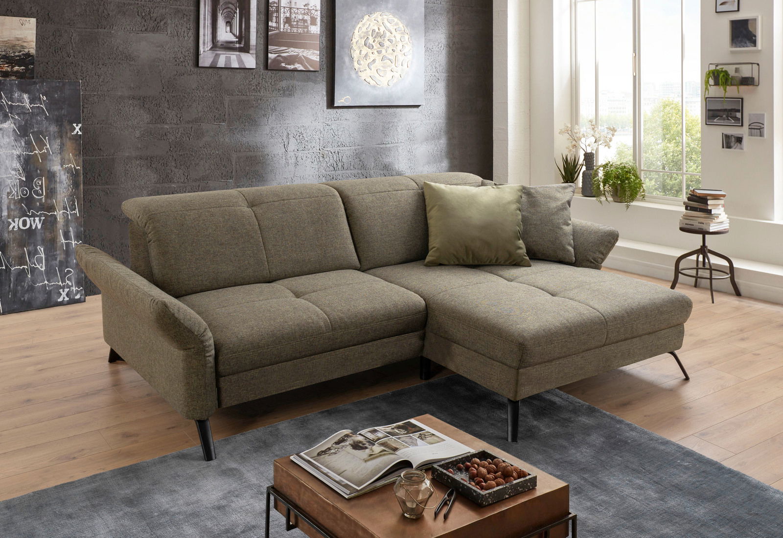 Gemütliche Rundecke in einem modernen Wohnzimmer, seitliche Perspektive, mit grauem Stoffbezug und dekorativen Kissen.