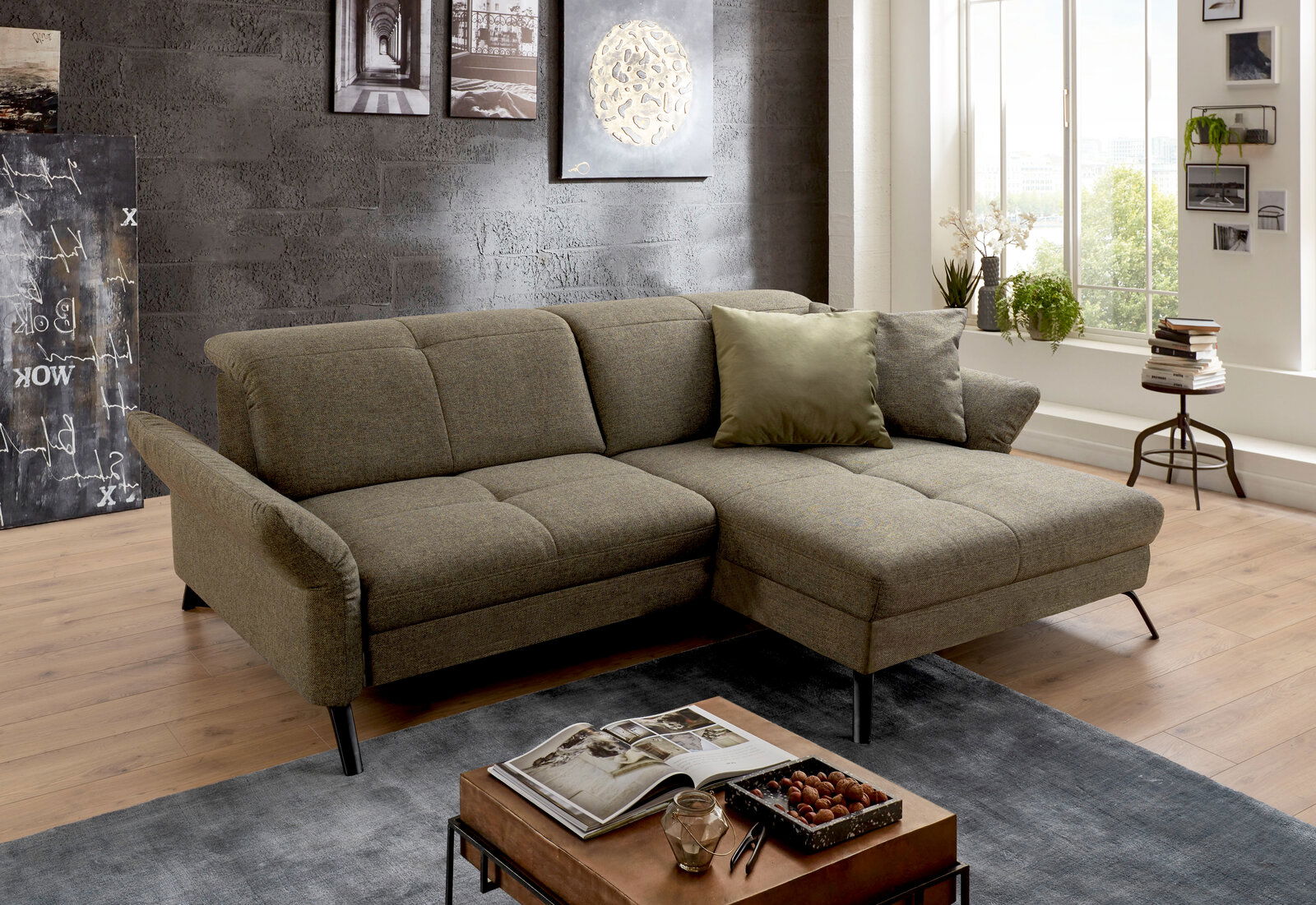 Gemütliche Rundecke in einem modernen Wohnzimmer, seitliche Perspektive, mit grauem Stoffbezug und dekorativen Kissen.