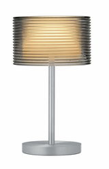 Moderne Akku-Tischleuchte GRAND GROVE mit geriffeltem, transparentem Lampenschirm und silbernem Standfuß, seitliche Perspektive.