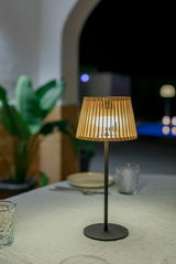 Solar-Tischleuchte mit Holzlamellen, auf einem Tisch bei Nacht, seitliche Perspektive