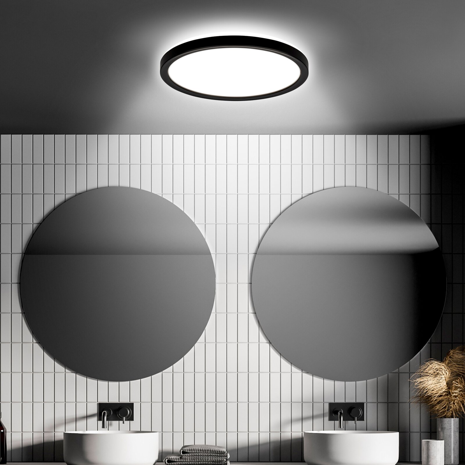 Briloner LED-plafondlamp met bewegingssensor MOVE Moderne led-plafondlamp met bewegingssensor, van onderaf gezien, in een stijlvolle badkamer met ronde spiegels en witte tegels.