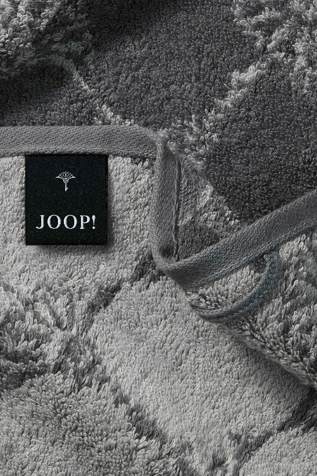Nahaufnahme eines grauen Gästetuchs mit geometrischem Muster und einem schwarzen Etikett mit der Aufschrift 'JOOP!'