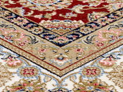 Nahaufnahme eines Orientteppichs mit traditionellem Keshan-Muster in Rot, Blau und Beige, schräg von oben fotografiert.