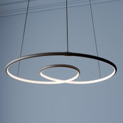 Moderne LED-Pendelleuchte mit zwei schwebenden Leuchtringen in Schwarz, warmweiß leuchtend, Ansicht von unten in leichter Untersicht vor blauem Hintergrund