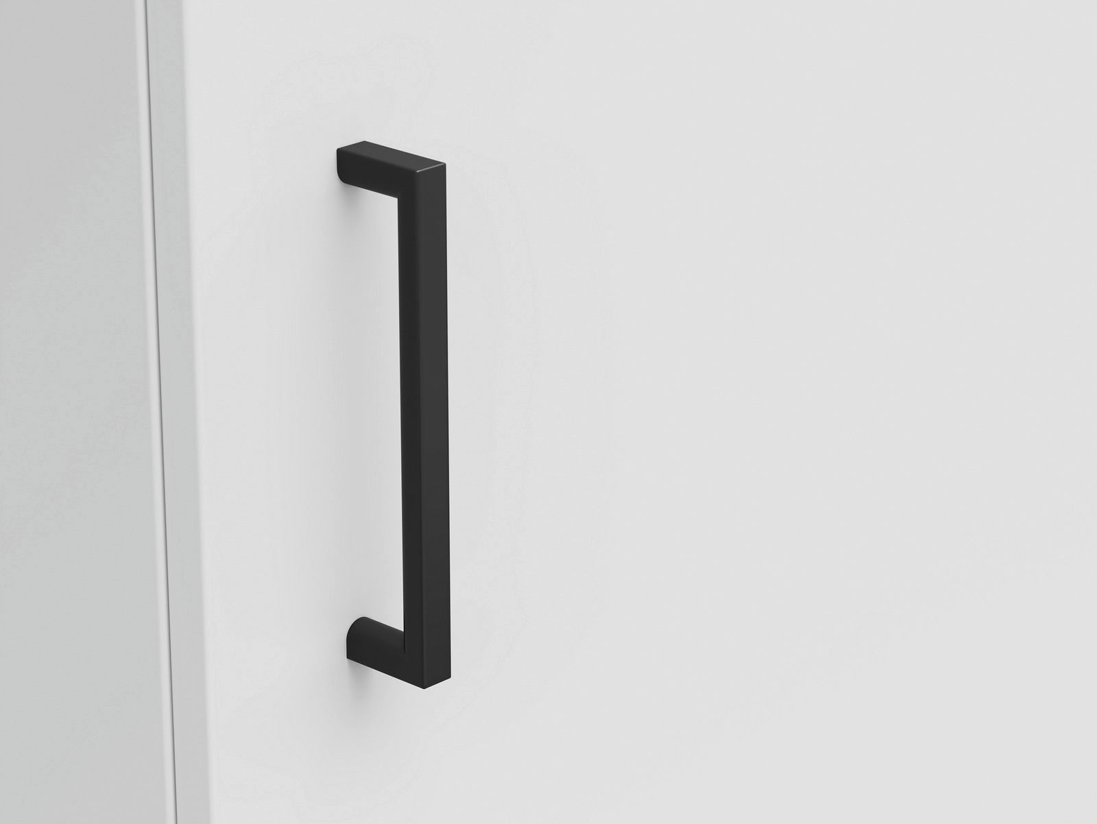 Nahaufnahme eines schwarzen Griffs an einer weißen Kommode, seitliche Perspektive