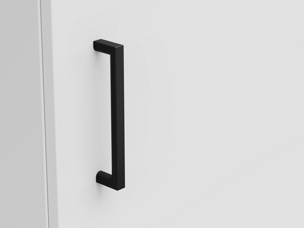 Nahaufnahme eines schwarzen Griffs an einer weißen Kommode, seitliche Perspektive