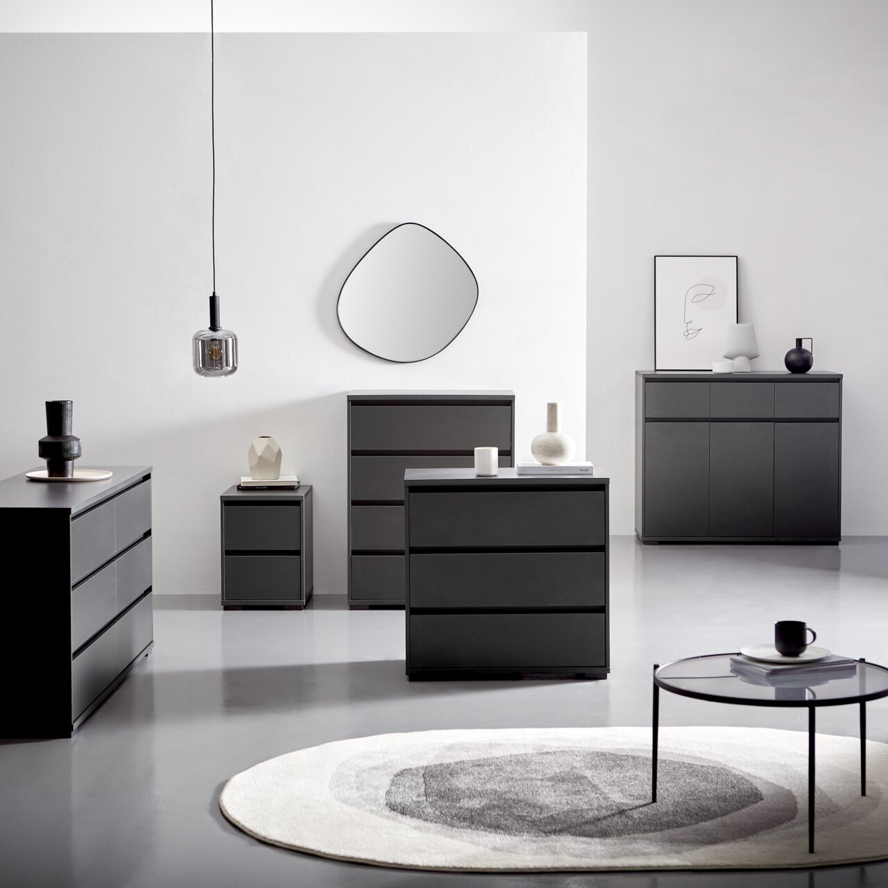 Carryhome Kommode LINE Moderne schwarze Kommoden und Sideboards in einem minimalistischen Raum, frontal und seitlich betrachtet, mit dekorativen Elementen und einem runden Teppich.