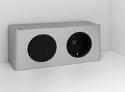 Silberne Steckdose mit zwei Anschlüssen, eine runde Abdeckung und eine Steckdose, seitliche Perspektive.