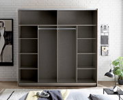 Offener Kleiderschrank in grauer Holzoptik mit Regalfächern links und rechts sowie zwei mittigen Kleiderstangen, frontal von vorn in einem hellen Schlafzimmer fotografiert.