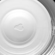 Blick von oben in eine weiße Tasse mit einem herzförmigen Relief am Boden.