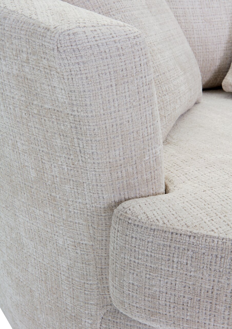 Nahaufnahme eines Sessels mit hellbeigem, strukturiertem Stoffbezug, Blick auf die Armlehne und Sitzfläche.