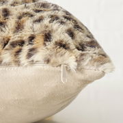 Nahaufnahme eines Kissens mit weichem, fellartigem Bezug und Reißverschluss, seitliche Perspektive.