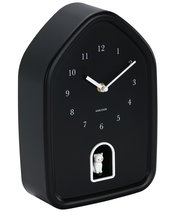 Schwarze Wanduhr in Hausform mit weißen Ziffern und Zeigern, sowie einer kleinen weißen Katze in einer Öffnung unten, seitliche Perspektive