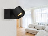 Schwarzer LED-Strahler an der Wand in einem modernen Wohnzimmer, seitliche Perspektive.