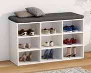 Weißes Schuhregal mit 9 offenen Fächern und schwarzem Sitzkissen, mit Schuhen bestückt und zwei Kissen obenauf, Ansicht schräg von vorne links.