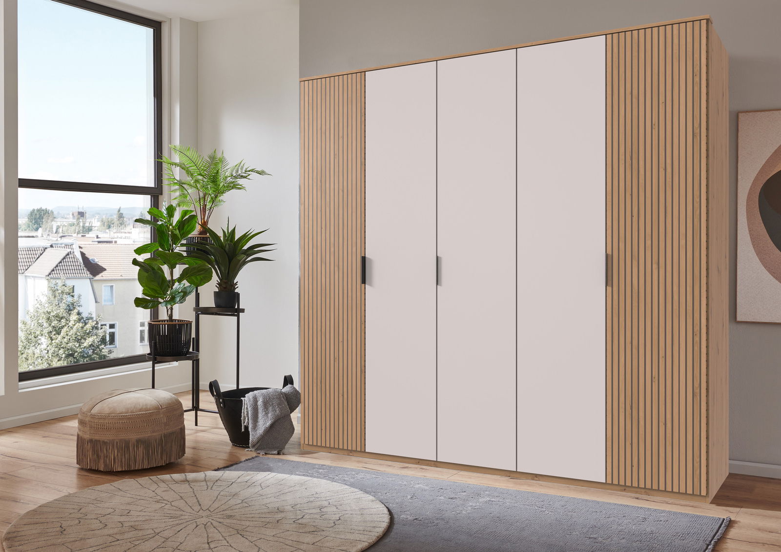 Moderner 5-türiger Drehtürenschrank Tunis in einem hellen Raum, seitliche Perspektive