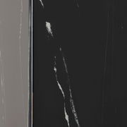 Nahaufnahme eines Beistelltisches mit schwarzer, marmorierter Oberfläche, seitliche Perspektive