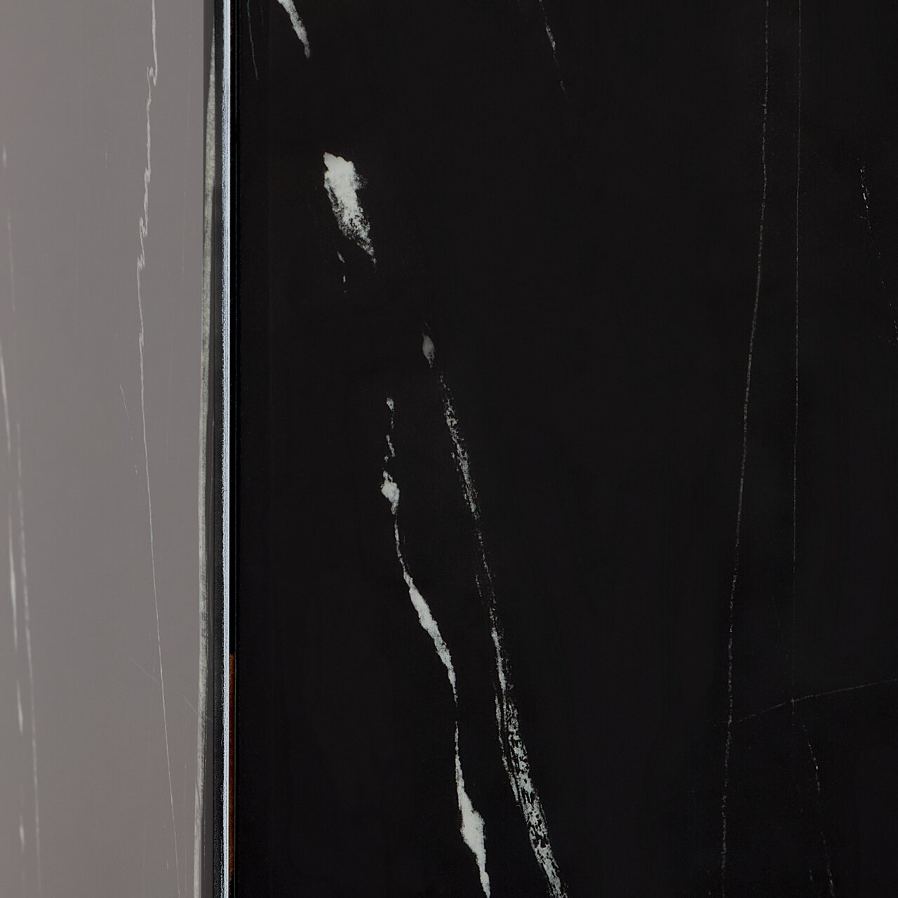 Nahaufnahme eines Beistelltisches mit schwarzer, marmorierter Oberfläche, seitliche Perspektive