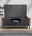 Modernes Lowboard in dunklem Design mit Holzakzenten, frontal betrachtet, mit Fernseher und Dekoration.