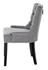 Seitenansicht eines grauen Stuhls mit gepolsterter Rückenlehne und Nietenverzierung, Modell SAVIK.