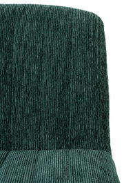 Close-up van een fauteuil met een groene, geribbelde stoffen bekleding, vooraanzicht